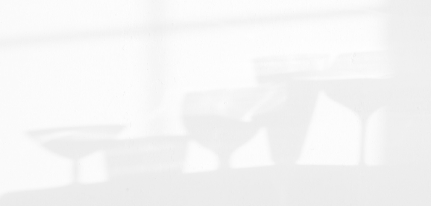 A row of wine glasses casting shadows on a wall.